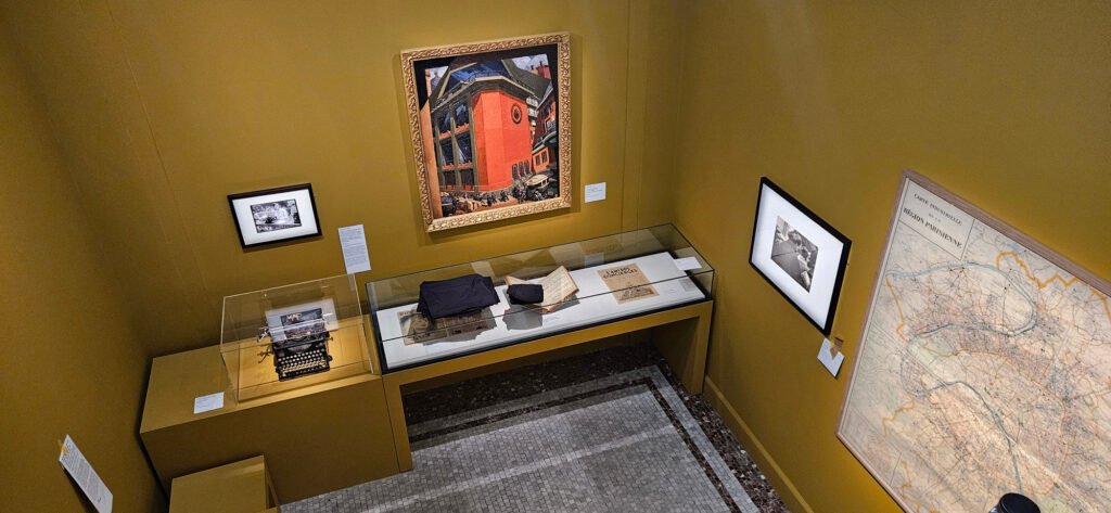 Œuvres encadrées et vitrine de documents éclairées au Musée Carnavalet.