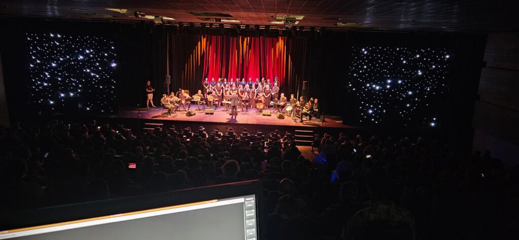 Scène de concert éclairée devant une salle sombre à l’Institut du Monde Arabe.