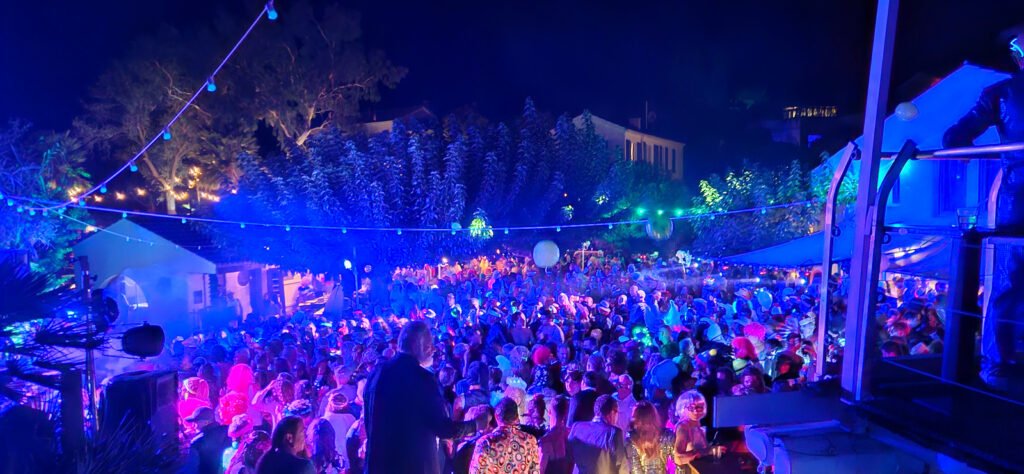 Éclairage bleu et magenta de la soirée Ferragosto à Hyères, avec les installations lumineuses au-dessus du public