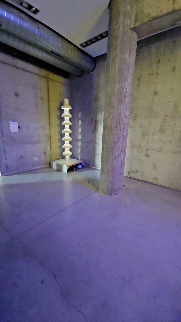 Gnomon lumineux de l’exposition SOLAIRE dans un espace en béton de l’église Saint-Pierre à Firminy
