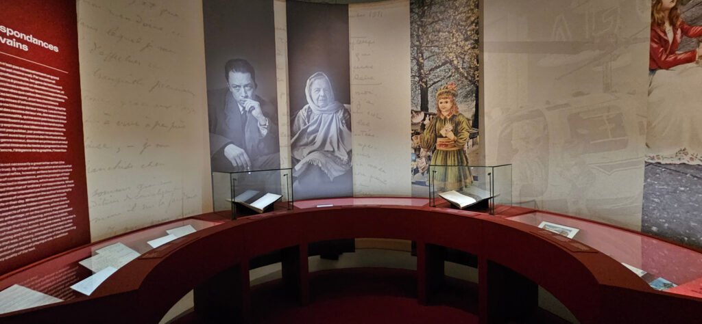 Vitrines et panneaux éclairés dans une salle de la Cité internationale de la langue française.